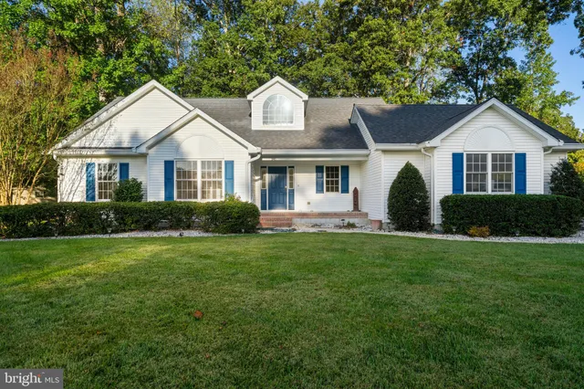 a front view of a house with a yard and trees