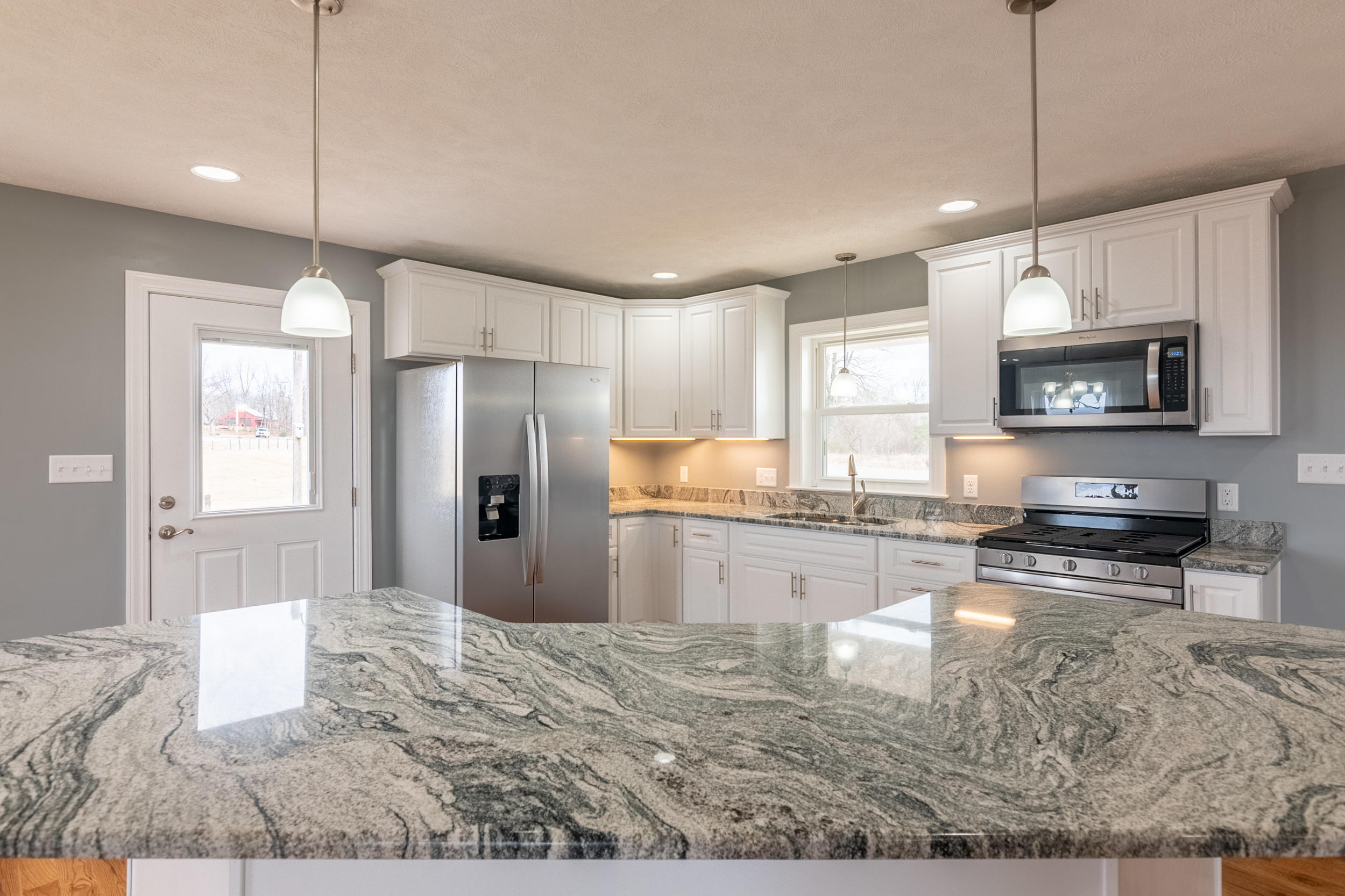 3338 Black Ridge Road Southwest Floyd, VA 24091 - Photo 14 of 38 a kitchen with stainless steel appliances granite countertop a refrigerator a stove top oven a sink a center island and chairs