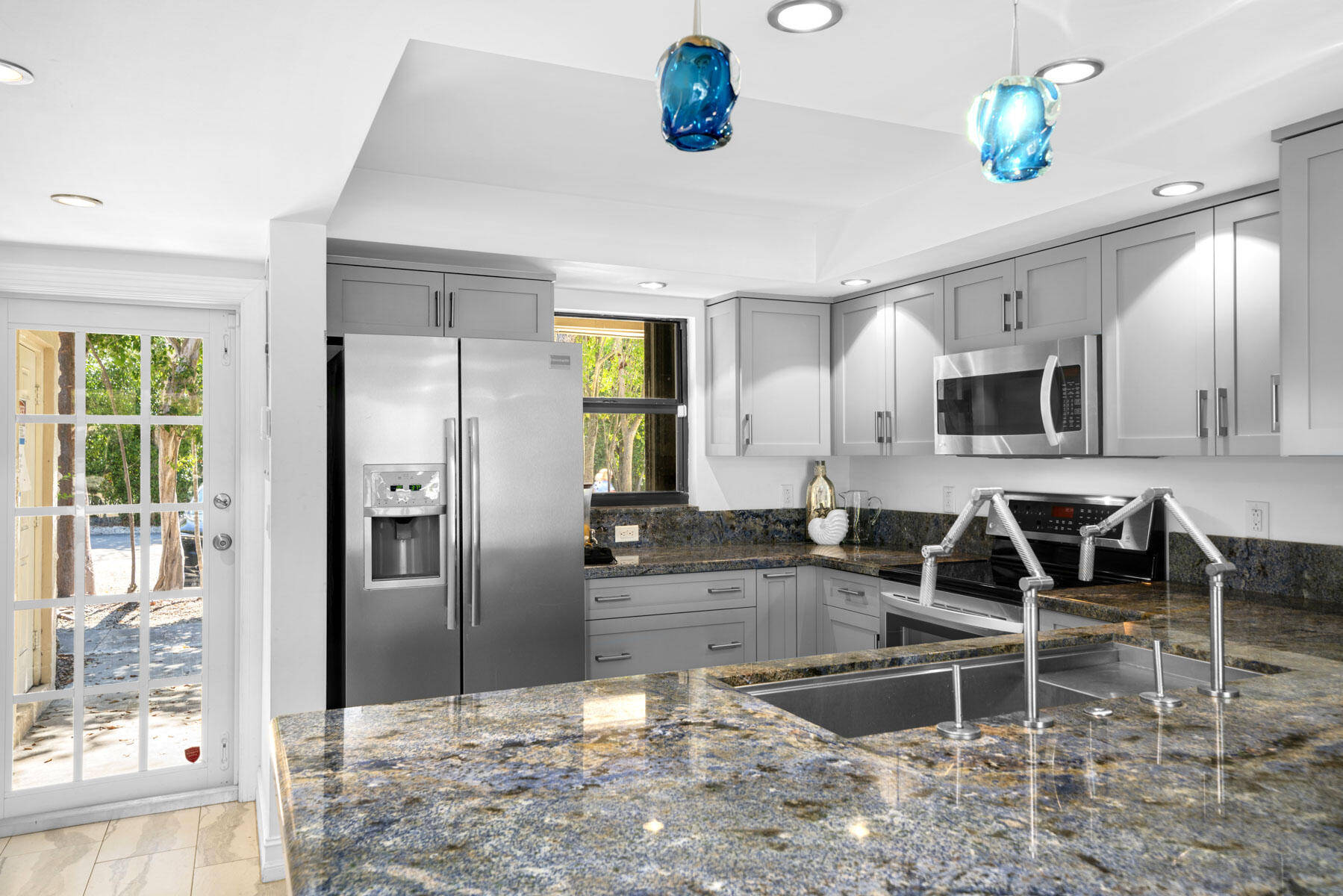 96000 Overseas Highway, Unit S3 AND 29' BOAT SLIP Key Largo, FL 33037 - Photo 10 of 38 a kitchen with granite countertop a refrigerator and a sink