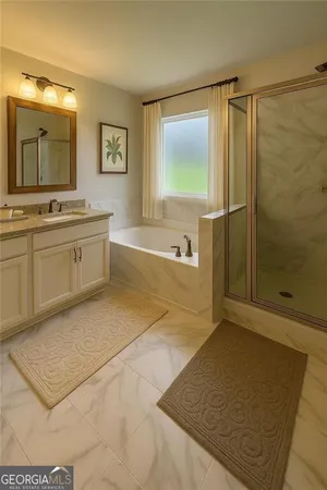 a spacious bathroom with a granite countertop sink a mirror and a bathtub