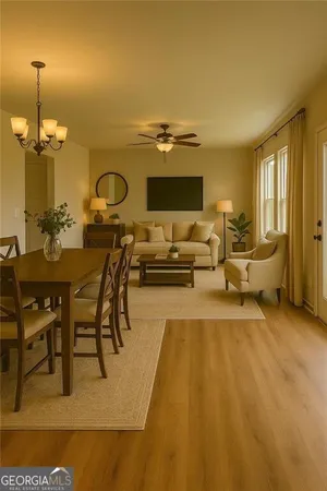 a living room with couches and kitchen view with wooden floor