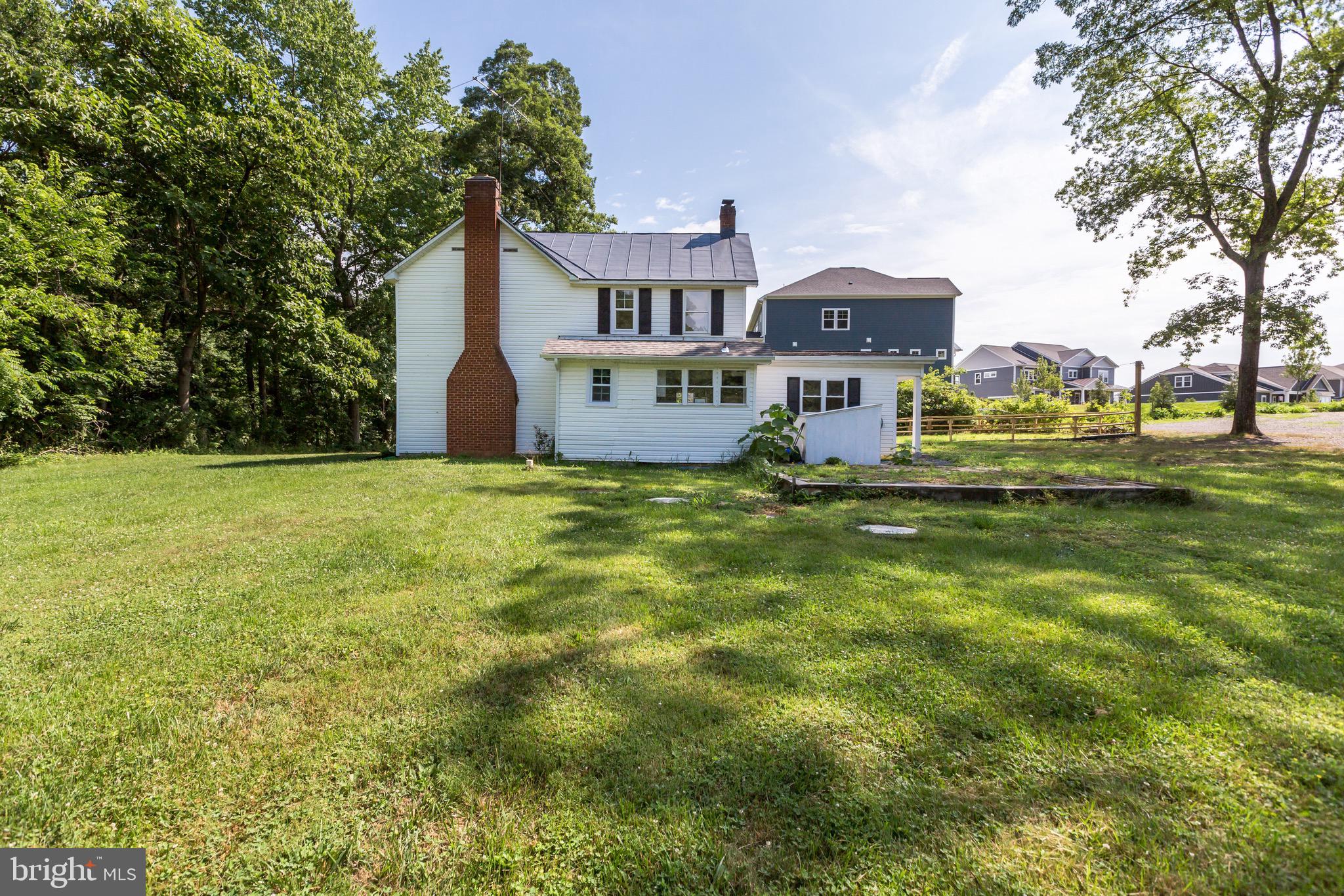 a view of a house with a big yard and large trees