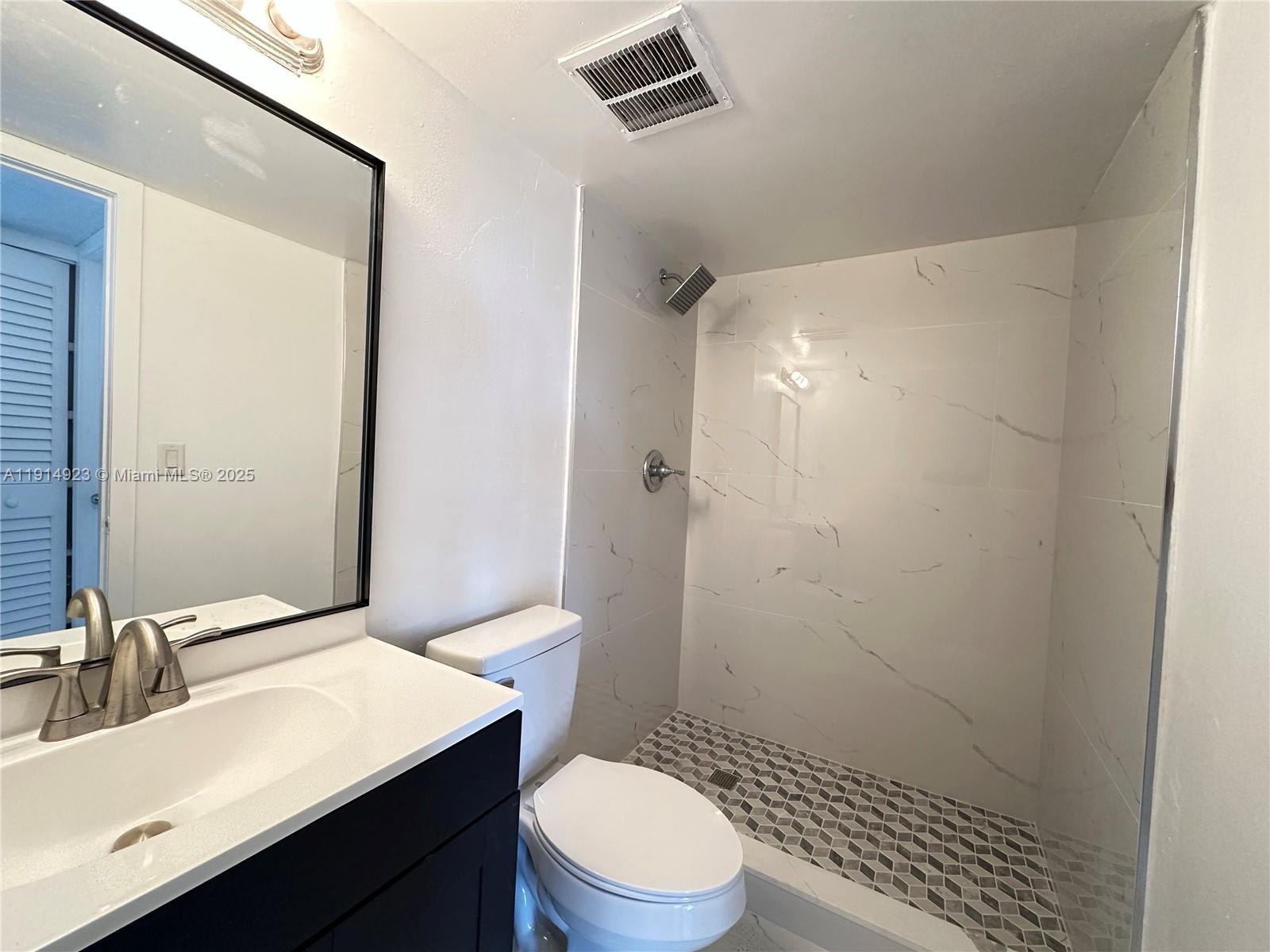7125 Northwest 186th Street, Unit B311 Hialeah, FL 33015 - Photo 15 of 25 a bathroom with a sink a toilet a shower and a mirror