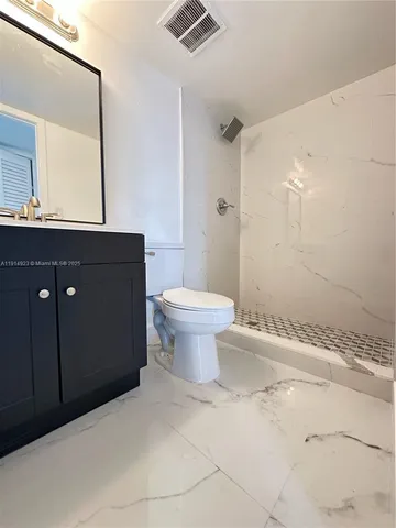 a bathroom with a sink toilet a mirror and shower