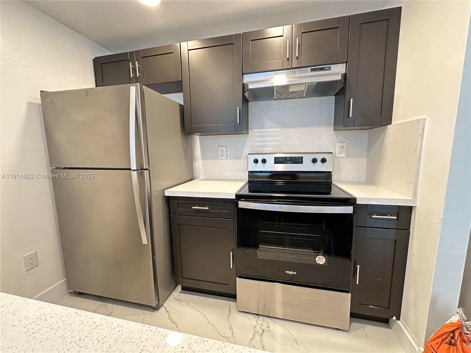 7125 Northwest 186th Street, Unit B311 Hialeah, FL 33015 - Photo 18 of 25 a kitchen with a stove and a refrigerator
