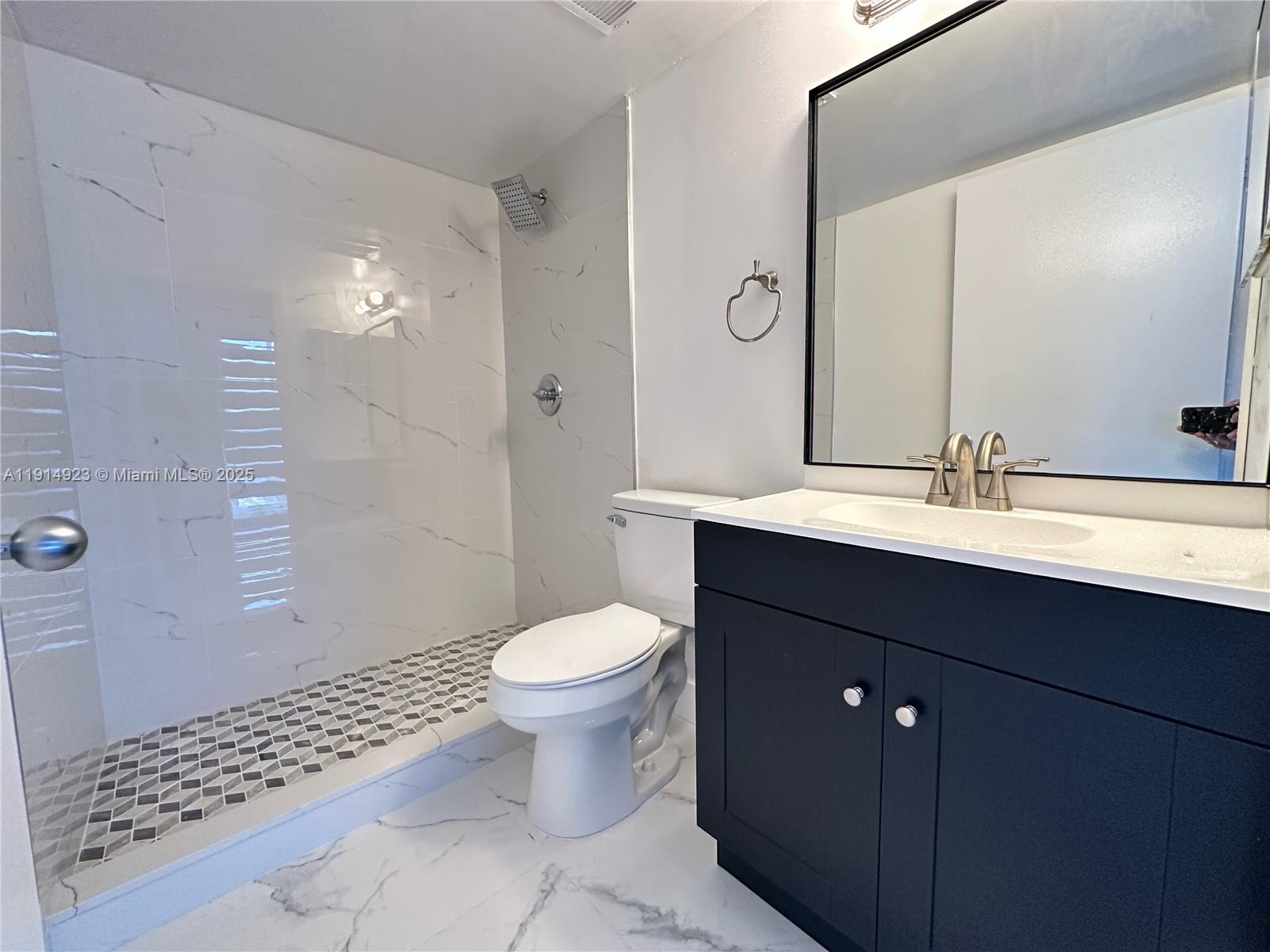 7125 Northwest 186th Street, Unit B311 Hialeah, FL 33015 - Photo 20 of 25 a bathroom with a sink toilet a mirror and shower