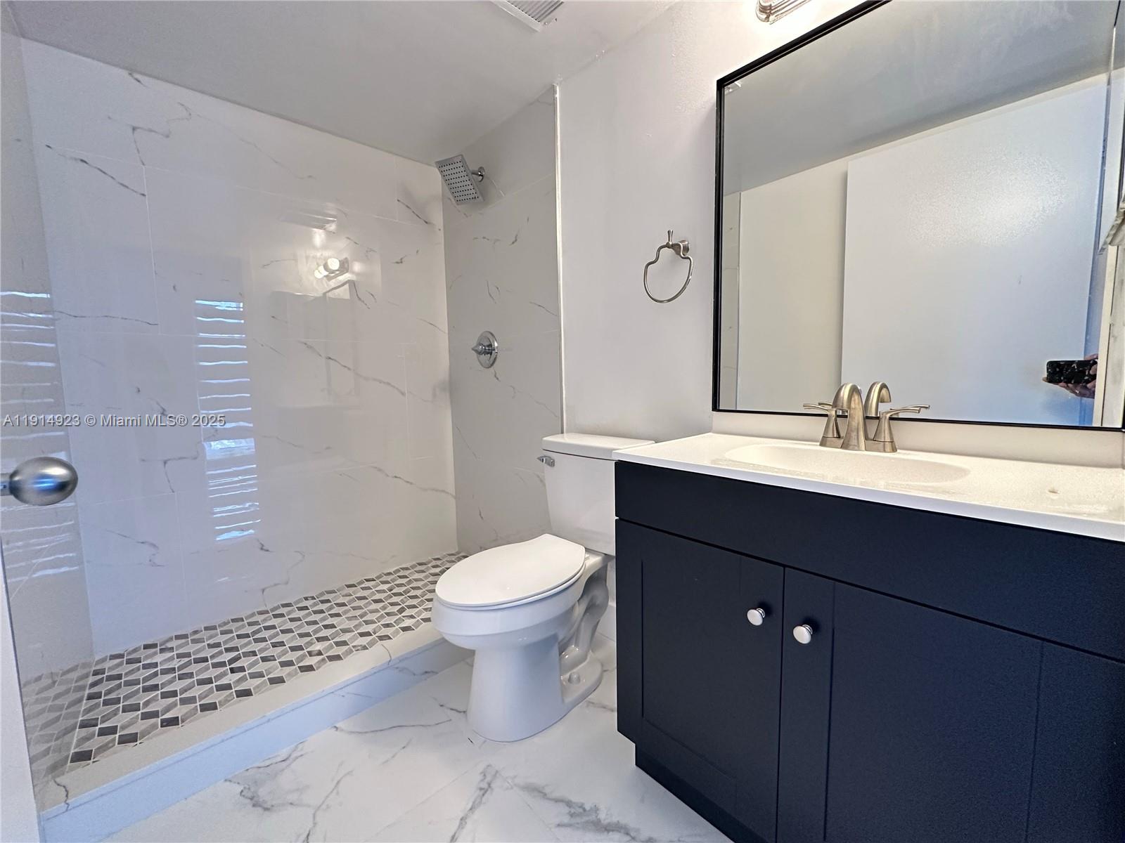 7125 Northwest 186th Street, Unit B311 Hialeah, FL 33015 - Photo 21 of 25 a bathroom with a sink toilet a mirror and shower