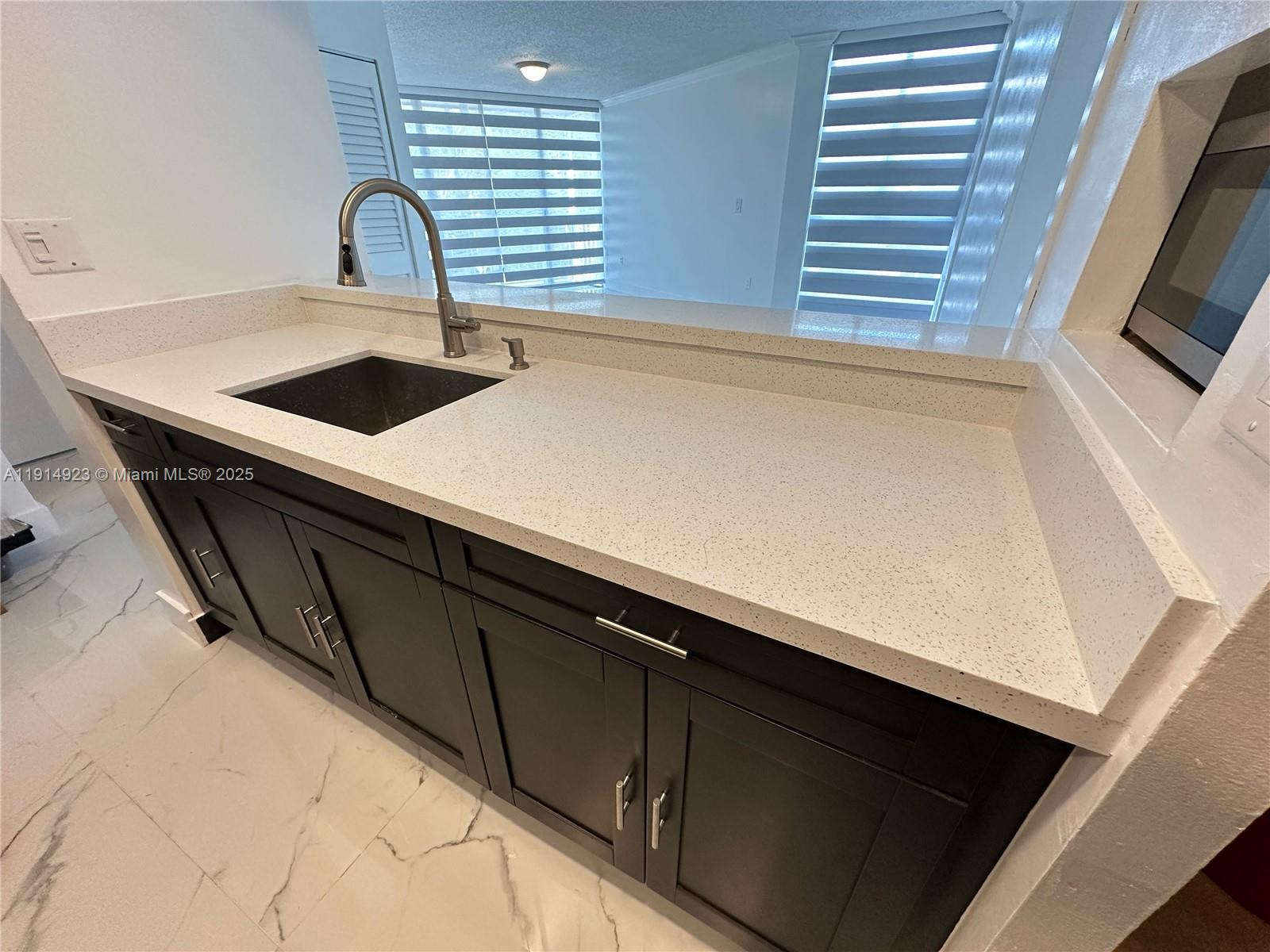 7125 Northwest 186th Street, Unit B311 Hialeah, FL 33015 - Photo 6 of 25 a kitchen with a sink and wooden floor