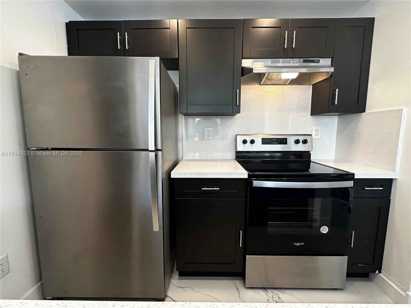 7125 Northwest 186th Street, Unit B311 Hialeah, FL 33015 - Photo 7 of 25 a kitchen with stainless steel appliances granite countertop a refrigerator a stove and a sink