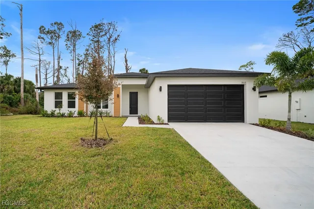 a front view of a house with a yard and garage