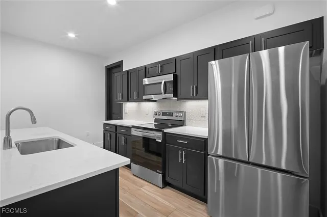 a kitchen with stainless steel appliances a refrigerator sink and microwave