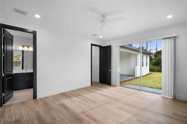a view of an empty room with closet and a bathroom