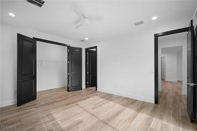 a view of a livingroom with wooden floor and a bathroom