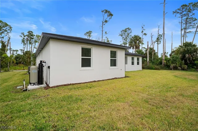 a view of a house with backyard and a tree
