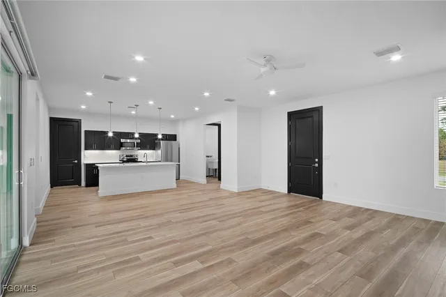 a view of kitchen with kitchen island sink refrigerator and white cabinets