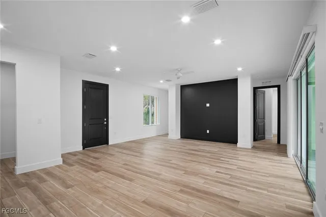 a view of an empty room with wooden floor and closet