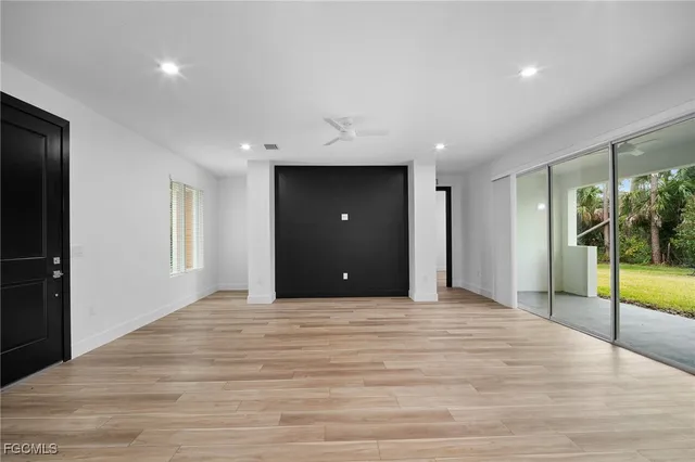 a view of an empty room with glass door and balcony