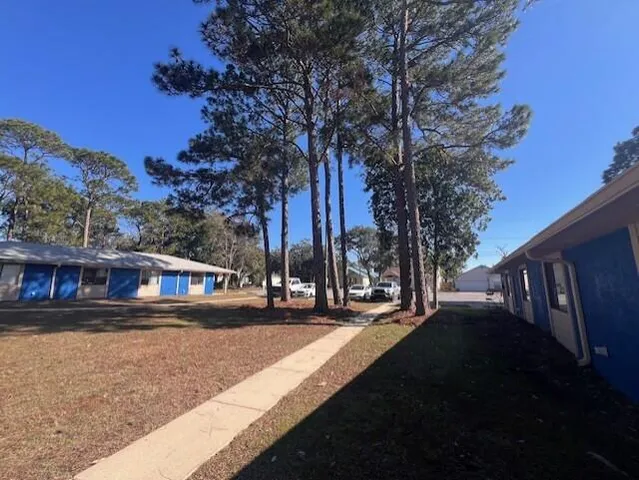 a view of street with house and trees in the background