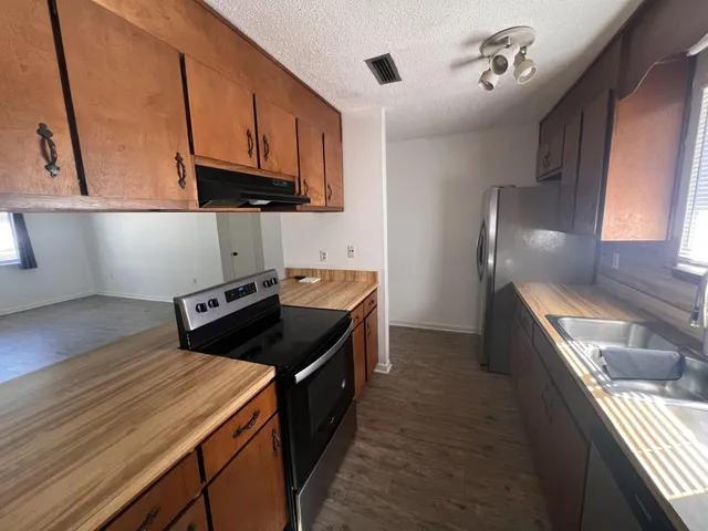 a kitchen with stainless steel appliances a stove sink and cabinets