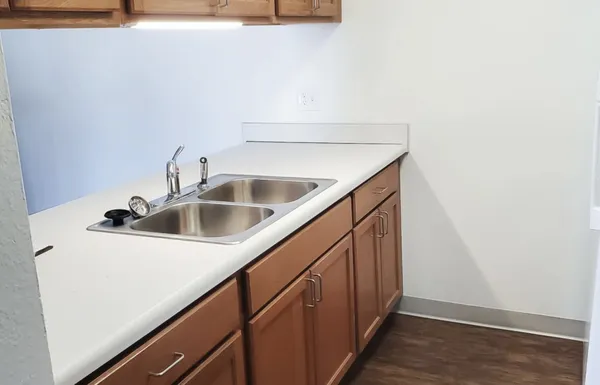 a utility room with sink and wooden floor