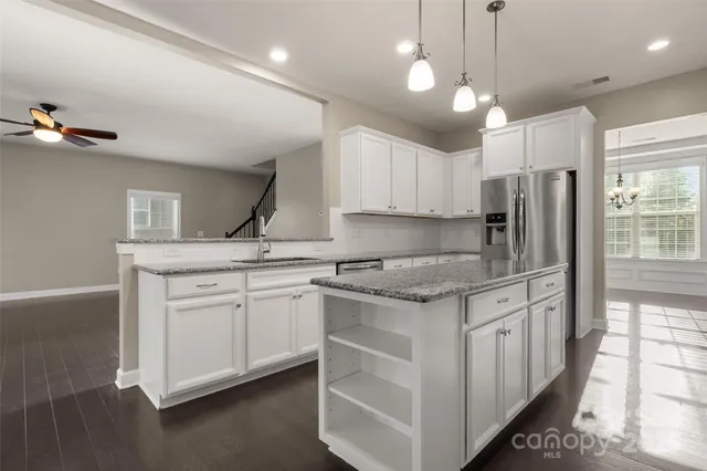 a kitchen with stainless steel appliances granite countertop a sink stove and refrigerator