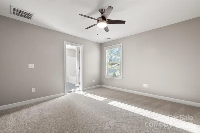 en empty room with windows and ceiling fan
