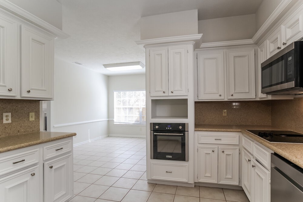 3407 El James Drive Spring, TX 77388 - Photo 7 of 17 a kitchen with granite countertop white cabinets stainless steel appliances and a sink
