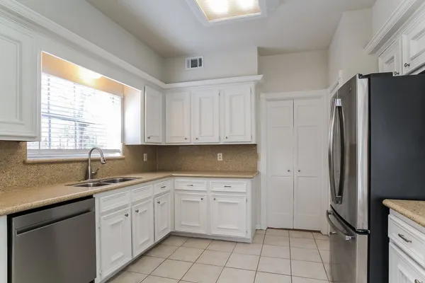 a kitchen with a sink window and cabinets