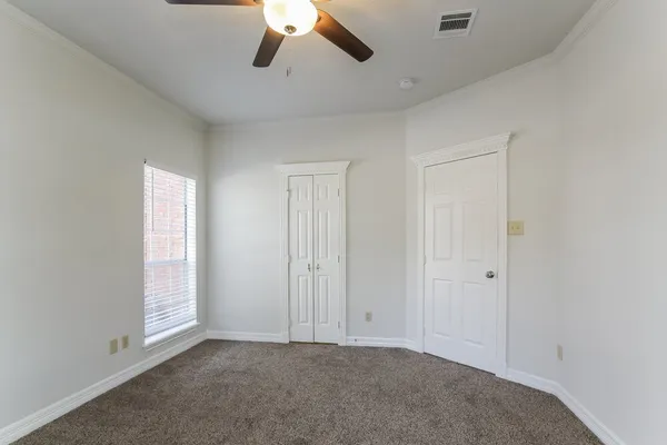 an empty room with chandelier fan