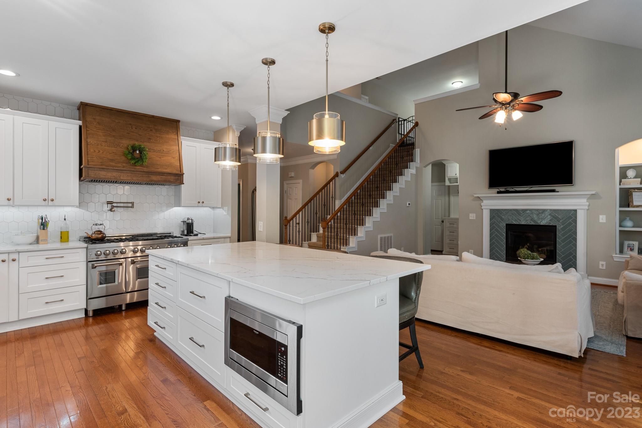 911 Stratford Run Drive Fort Mill, SC 29708 - Photo 22 of 45 a kitchen with kitchen island a stove a sink and a fireplace