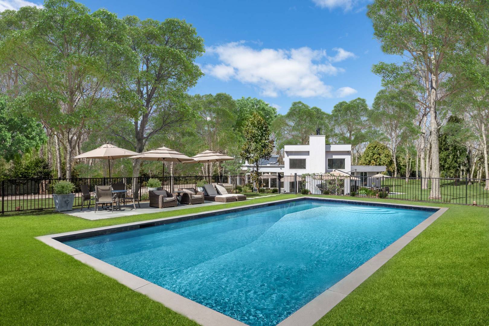 81 Neck Path East Hampton, NY 11937 - Photo 3 of 24 a view of a swimming pool with lawn chairs under an umbrella