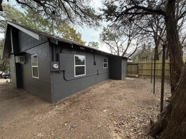 a backyard of a house with large trees and a barn