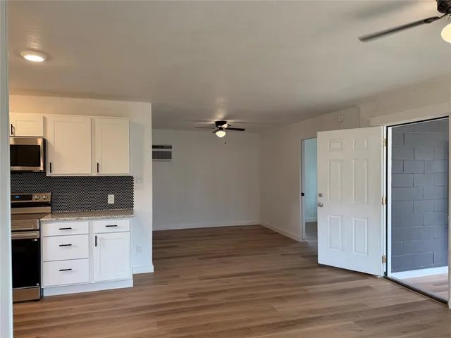 an empty room with wooden floor and cabinet