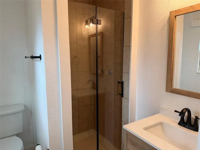 a bathroom with a sink a toilet and shower