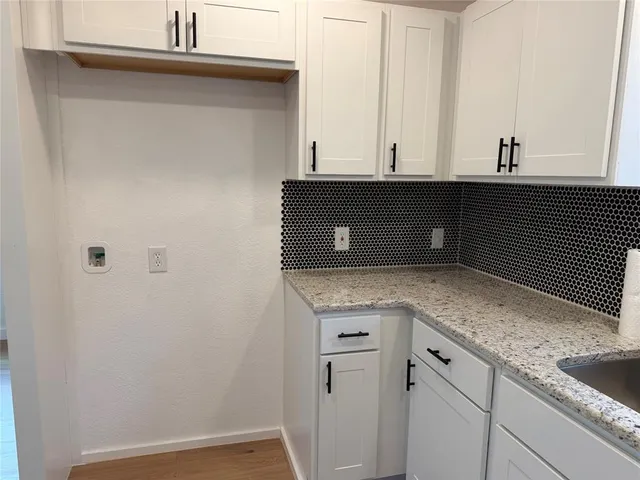 a kitchen with granite countertop a sink and cabinets