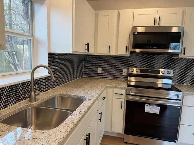 a kitchen with a sink stove and microwave
