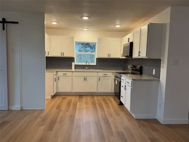 a kitchen with a sink cabinets and wooden floor