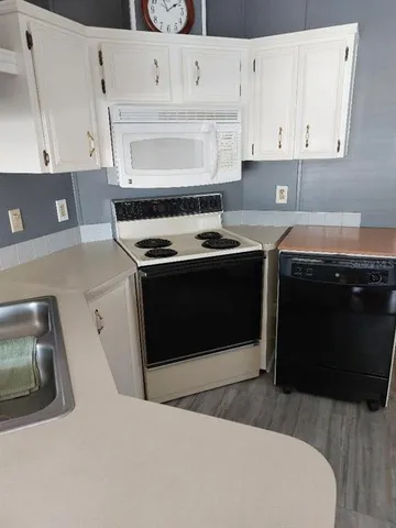 a kitchen with stainless steel appliances granite countertop a stove a sink and white cabinets