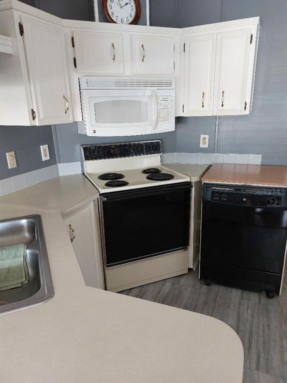 12531 Southeast 140th Avenue, Unit 118 Okeechobee, FL 34974 - Photo 11 of 26 a kitchen with stainless steel appliances granite countertop a stove a sink and white cabinets