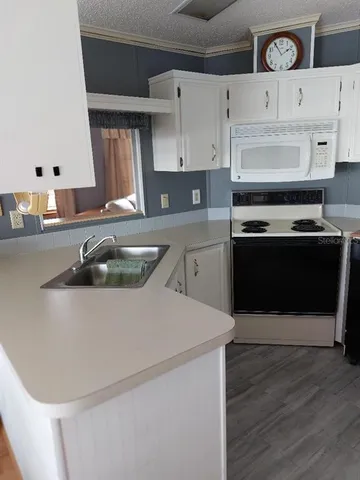 a kitchen with stainless steel appliances granite countertop a sink a stove and a refrigerator