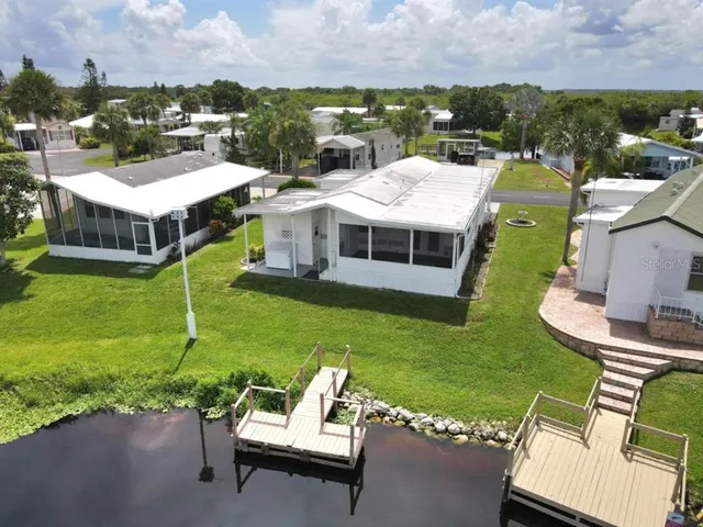 an aerial view of a house with a garden and lake view