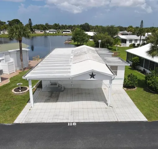 an aerial view of a house with a yard and lake view