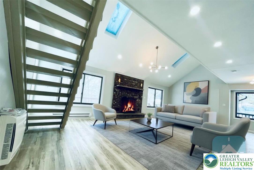 103 Ashley Court Bushkill, PA 18324 - Photo 24 of 68 The living room features high ceilings with skylights and an open floor concept, in a virtually staged, unfurnished house.
