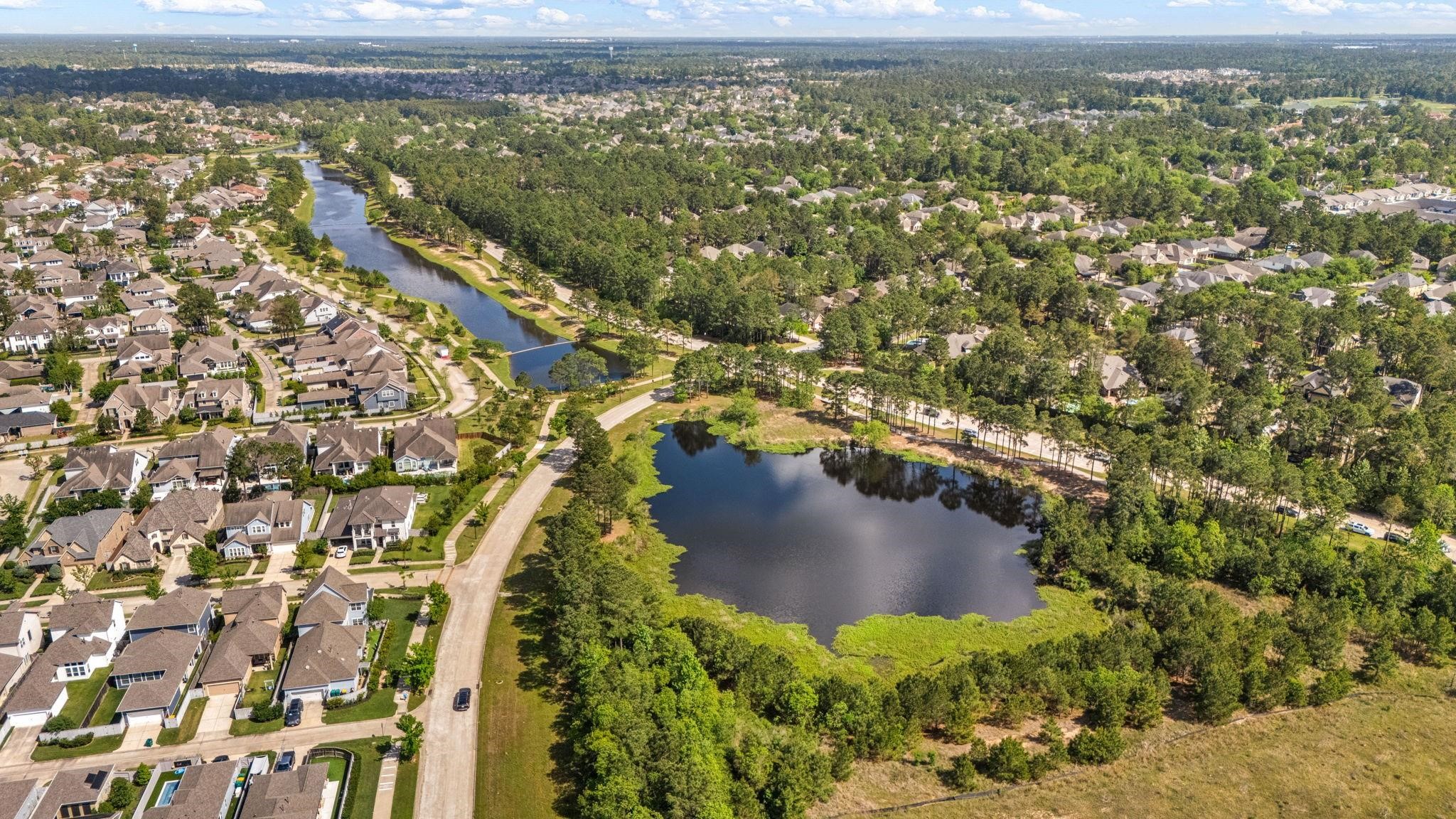 98 Herons Flight Place Spring, TX 77389 - Photo 25 of 29 This expansive aerial view highlights the community lake that weave through the neighborhood, offering residents miles of scenic trails and peaceful waterfront vistas. Perfectly positioned to embrace the outdoors while remaining just minutes from the vibrant amenities of The Woodlands, this is truly the pinnacle of suburban living.