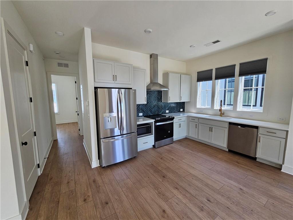 1294 Longreen Terrace Northwest, Unit 2 Atlanta, GA 30318 - Photo 6 of 25 a kitchen with stainless steel appliances wooden floors and wooden cabinets