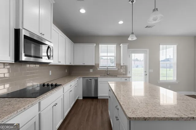 a kitchen with stainless steel appliances granite countertop stove microwave and window