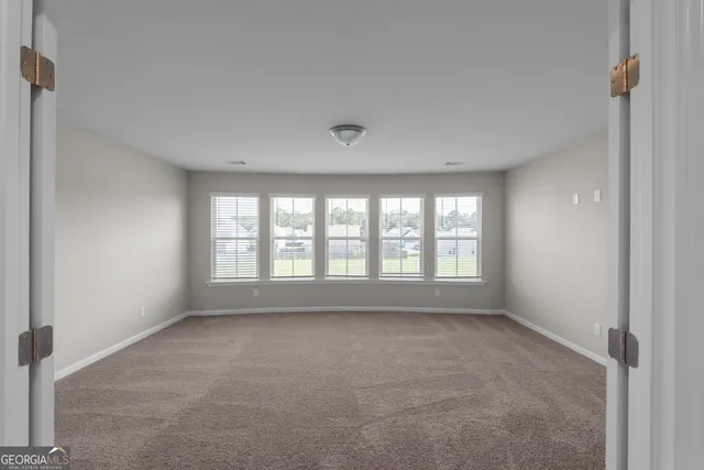 a big room with windows and chandelier fan