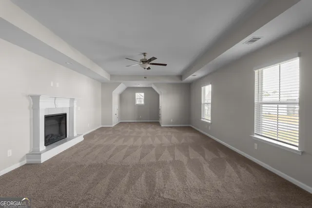 a view of an empty room with a fireplace and a window