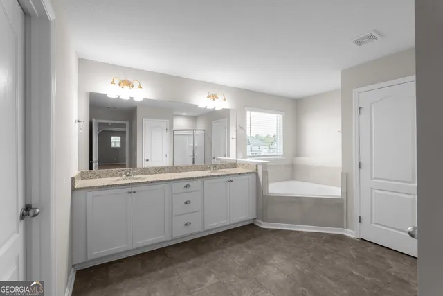 a large bathroom with a large tub and sink