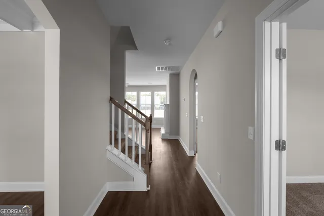 a view of a hallway with wooden floor and staircase